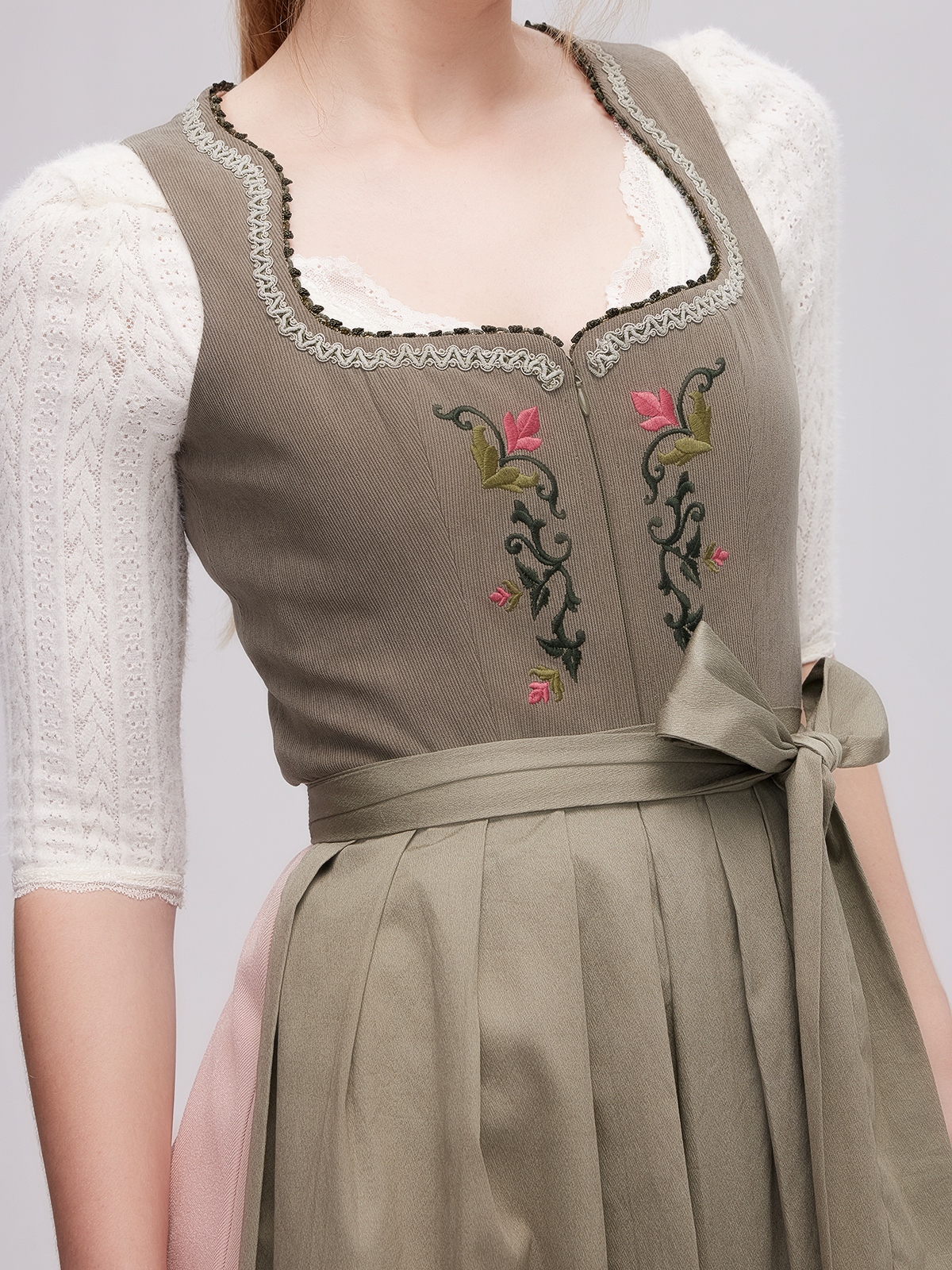 Ein grünes Dirndl mit traditioneller Schürze